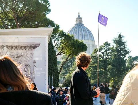 Guide with a tour flag on a Vatican Museums terrace, St. Peter's dome behind the trees, Vatican pass ticket group