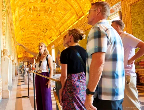 Guide pointing up at the gilded Gallery of Maps ceiling for a small group on a Vatican pass ticket tour