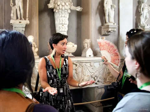 Guide talking to a group beside ancient marble statues in the Vatican Museums on a Vatican pass ticket
